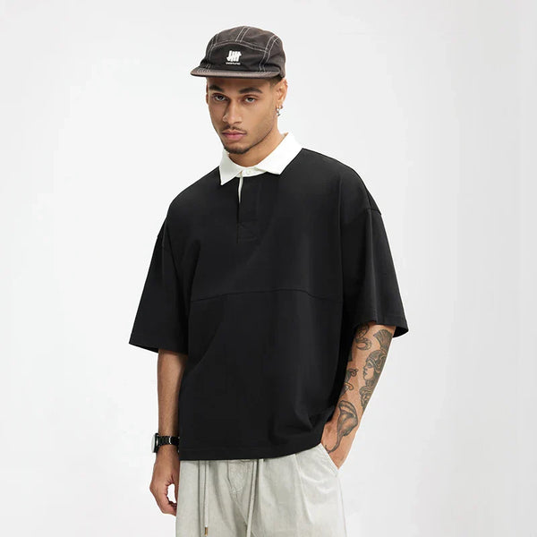 Model wearing the black Placket Polo T-Shirt in a gray background