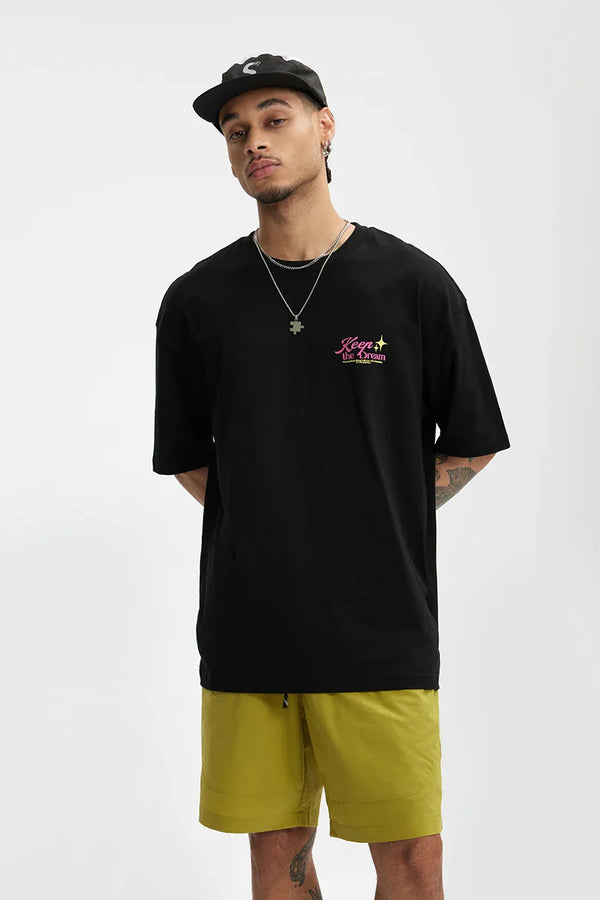 Model wearing the black Dream Forge Apparel T-Shirt in a gray background